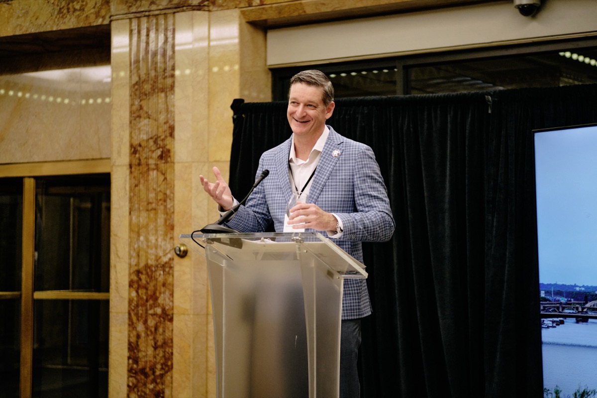 Jamie Rand speaking in the marble lobby of the First National Bank Building
